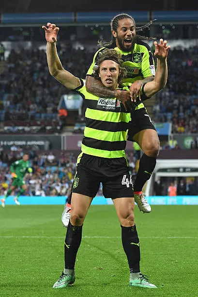Sean Scannell celebrating a Huddersfield Town goal with Michael Hefele, lime green away kit
