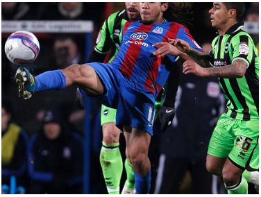 Sean Scannell in Crystal Palace home kit, stretched acrobatic kick