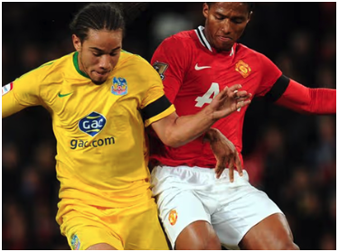 Sean Scannell in Crystal Palace yellow away kit, contesting a ball against Manchester United